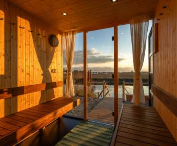 a wooden sauna with a view of a body of water