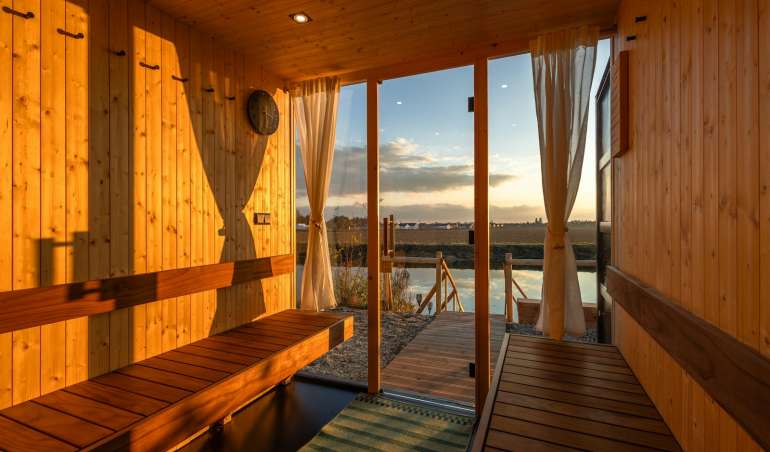 a wooden sauna with a view of a body of water
