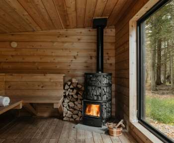 A wood burning stove inside of a wooden cabin
