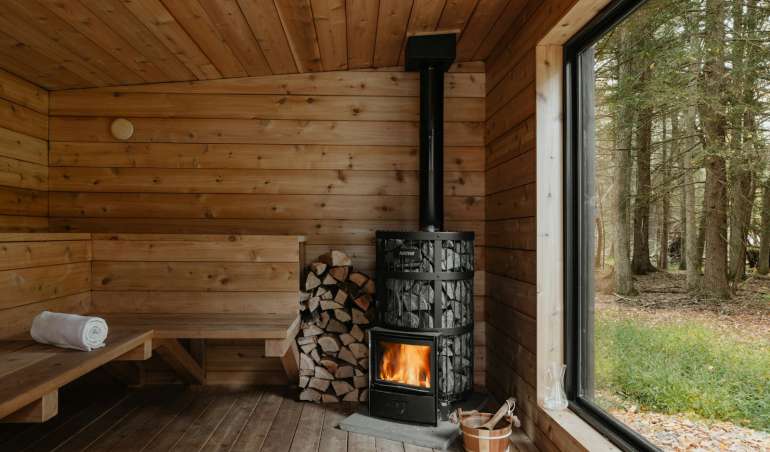 A wood burning stove inside of a wooden cabin