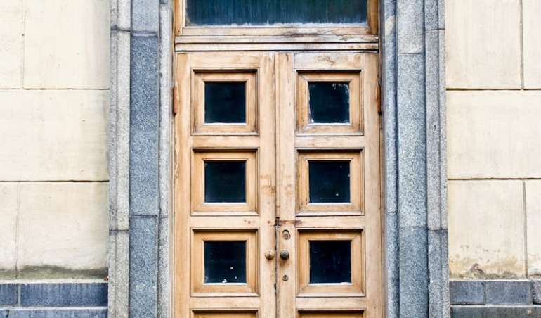 white concrete building showing closed door
