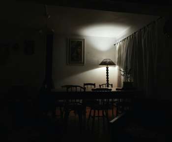 a dark room with a table and a lamp